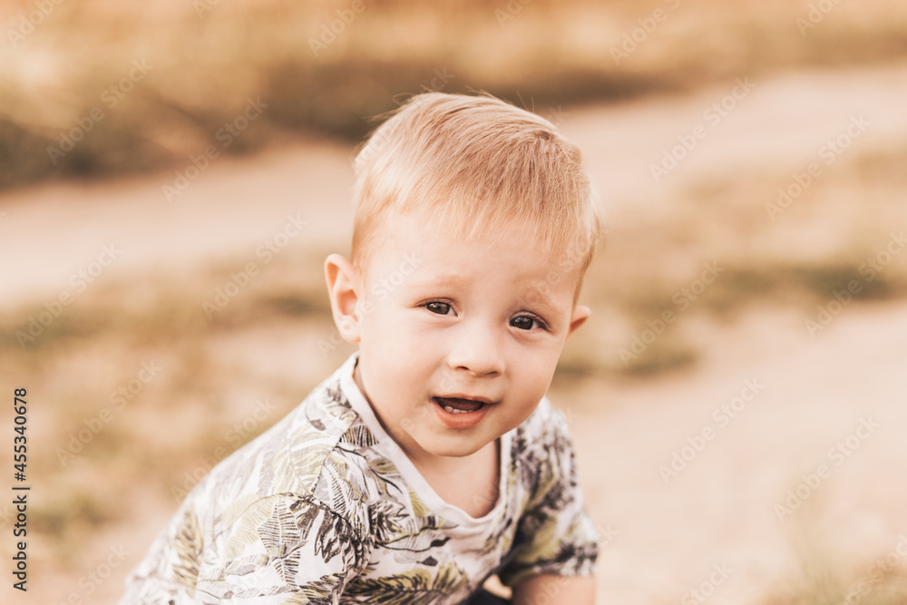Little boy walking through the field in the summer. Childhood. Summertime. Summer vacation Little boy walking through the field in the summer. Childhood. Summertime. Summer vacation