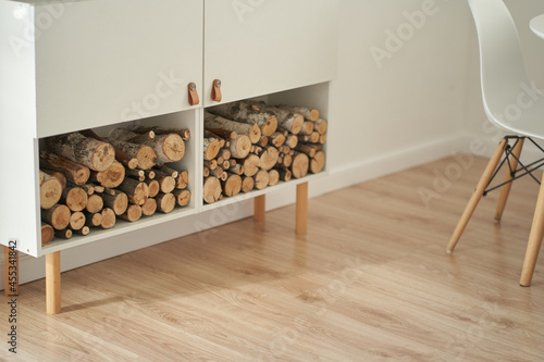 Stocks of firewood for the fireplace are stacked on the shelves. Background of dry chopped wood logs in a pile, on a white shelf. High quality photo photo