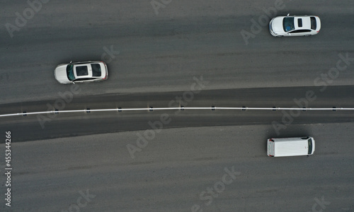 Aerial top view of three cars driving on urban highway with guardrail