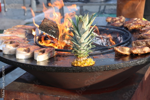coconut and fresh meat cooking on metal plate