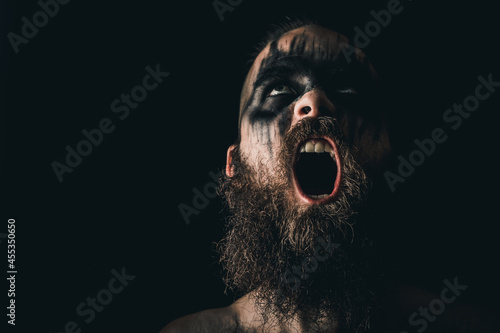 Obraz na plátne Portrait of a Viking warrior with black war paint, screaming with rage and anger