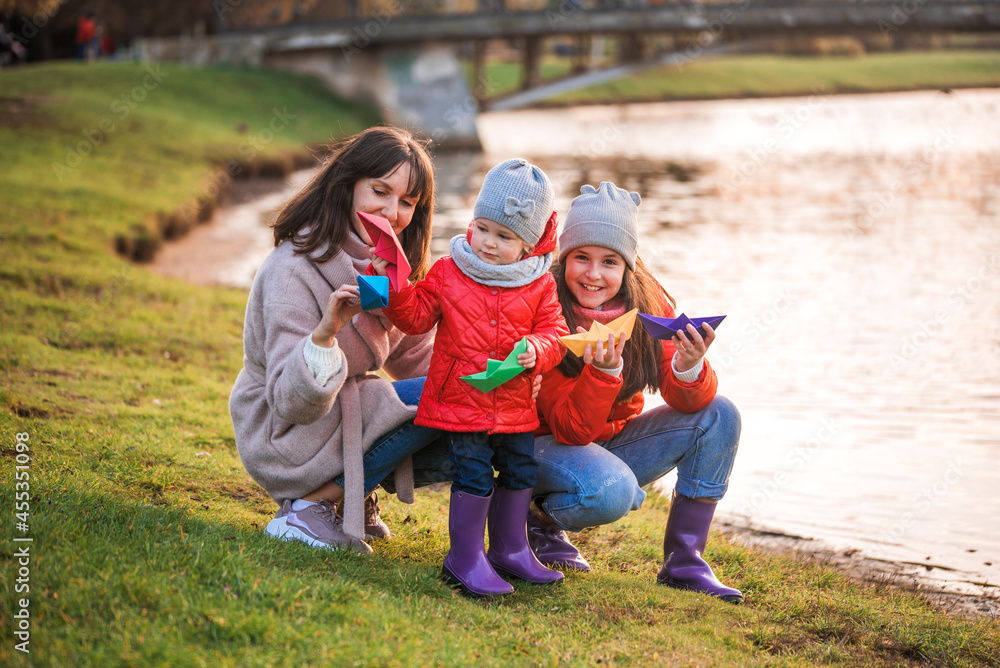 Fototapeta premium child playing with paper boats in spring water.lake or river