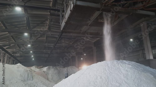 Ammonium sulfate powder pour in a pile inside a warehouse of chemical plant. Mineral organic fertilizers for agriculture industry.