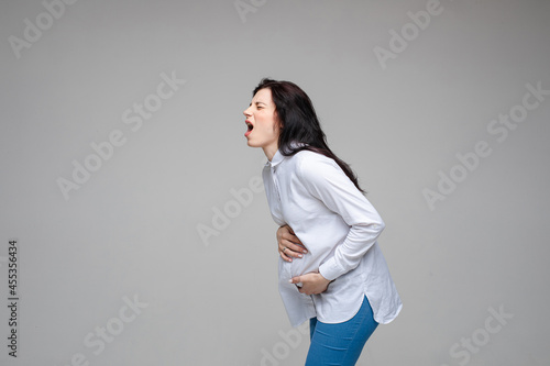 beautiful young pregnant woman screaming beacuse of a strong stomach ache photo