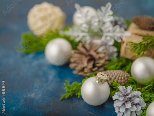 Stylish original Christmas and New Year composition on a blue background. Coniferous branches  Christmas balls  cones  snowflake. Handmade. New Year  Christmas  interior decor.