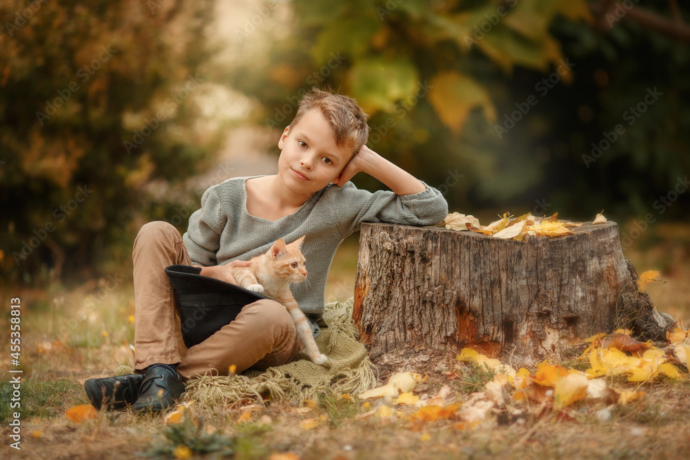 Boy with red cat ones autumn garden background close up photo. Kid with ginger cat on a autumn background. Beautiful autumn portrait of boy with ginger cat in the hat. Boy with red cat ones autumn garden background close up photo. Kid with ginger cat on a autumn background. Beautiful autumn portrait of boy with ginger cat in the hat.
