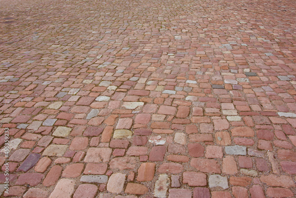 Old cobblestone pavement. Stone paved road in perspective