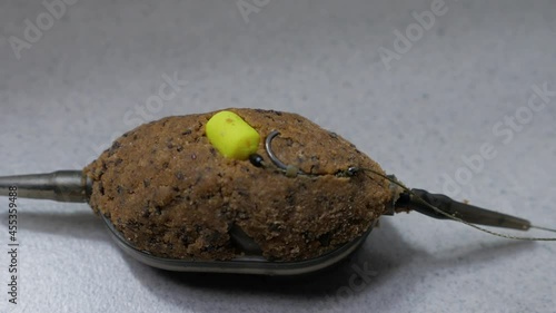 Flat Feeder fishing tackle with groundbait and small yellow pop-up photo