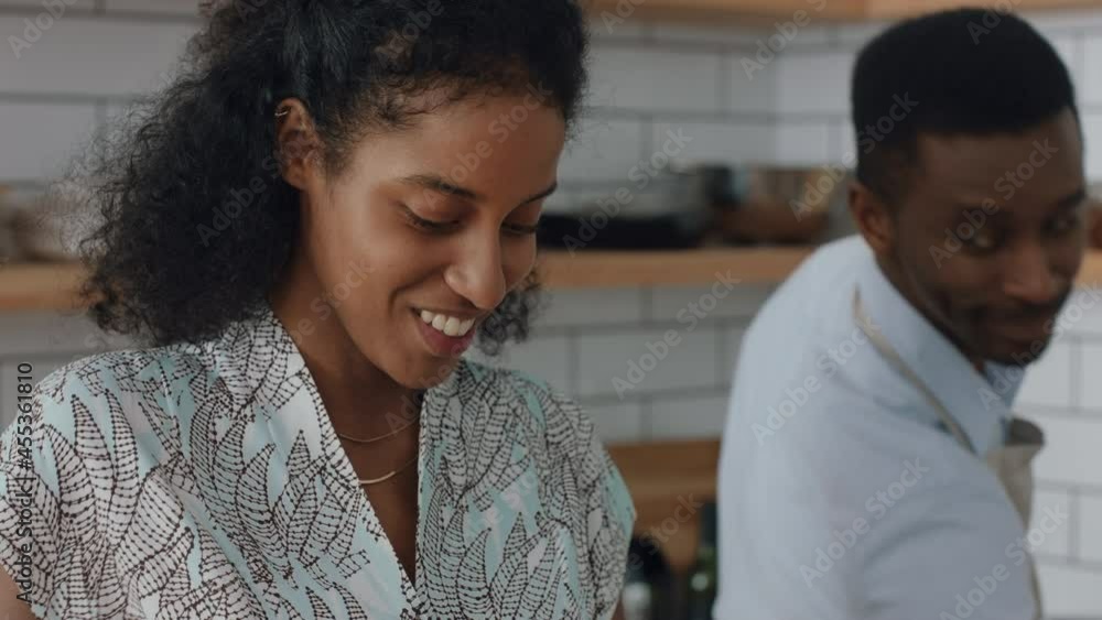 happy young mixed race couple cooking together in kitchen preparing dinner woman chopping vegetables helping boyfriend enjoying healthy lifestyle making food at home 4k happy young mixed race couple cooking together in kitchen preparing dinner woman chopping vegetables helping boyfriend enjoying healthy lifestyle making food at home 4k