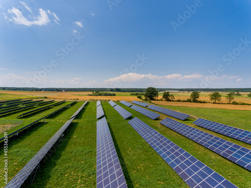 Photovoltaic farm - renewable energy from sunlight - photovoltaic panels set on a green field. Renewable energy supplying medium-sized enterprises
