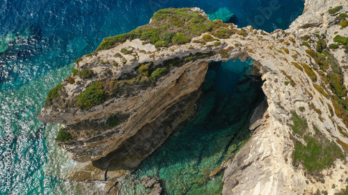 Aerial drone photo of scenic rock formation and natural arch of Tripitos over turquoise crystal clear Ionian sea, Paxos island, Greece
