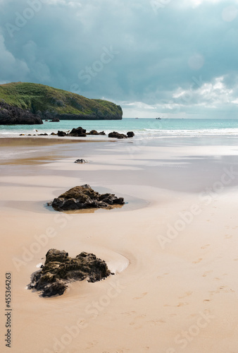 Playa de Celorio, preciosa playa de piedras que forman una composición espectacular. Agua turquesa del Cantabrico junto a el cielo nublado y la arena fina.