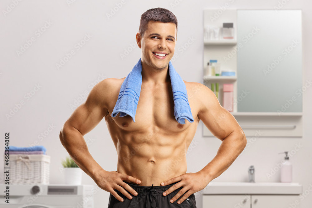 Obraz premium Handsome young shirtless man standing in a bathroom