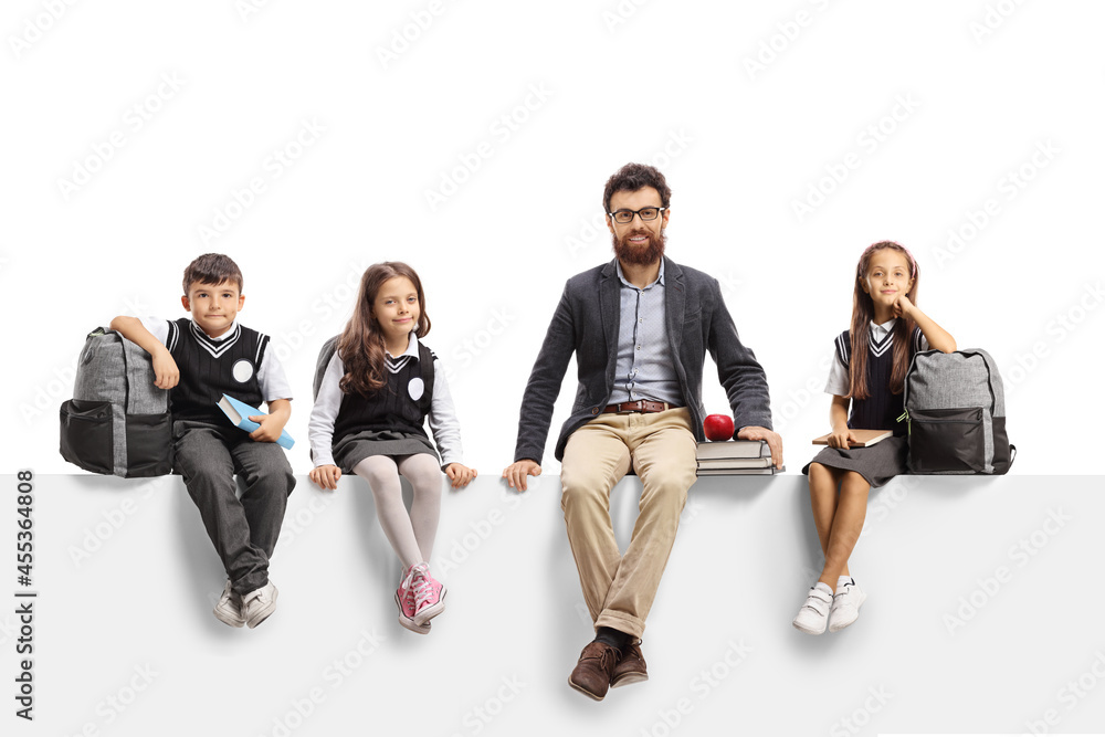 Fototapeta premium Schoolchildren and a male teacher with books sitting on a blank panel