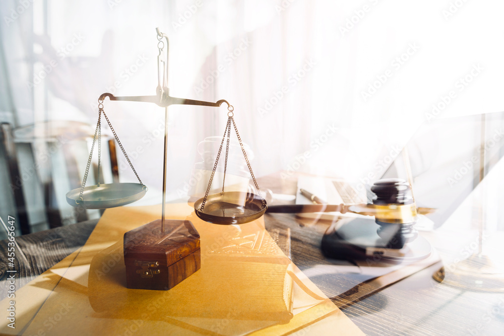 Business and lawyers discussing contract papers with brass scale on desk in office. Law, legal services, advice, justice and law concept Business and lawyers discussing contract papers with brass scale on desk in office. Law, legal services, advice, justice and law concept