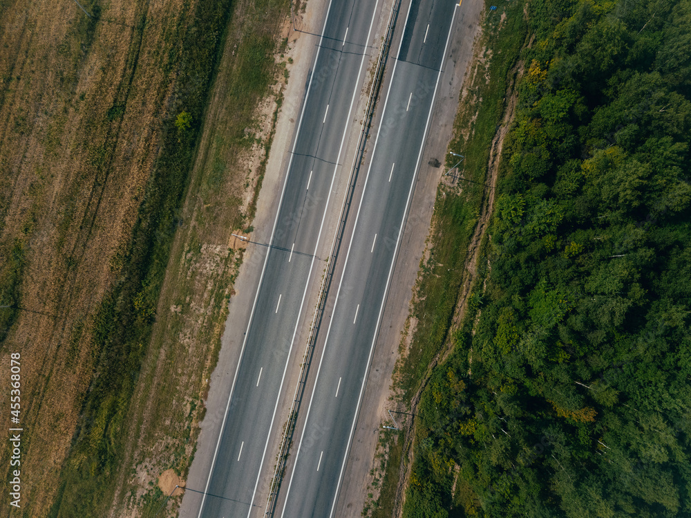 Fototapeta premium A view from above of an empty paved road in the countryside. 
