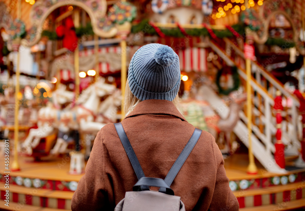 blonde woman near carousel at the Christmas market blonde woman near carousel at the Christmas market