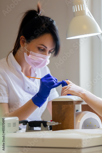 Canvas Print manicure master applying a nail polish