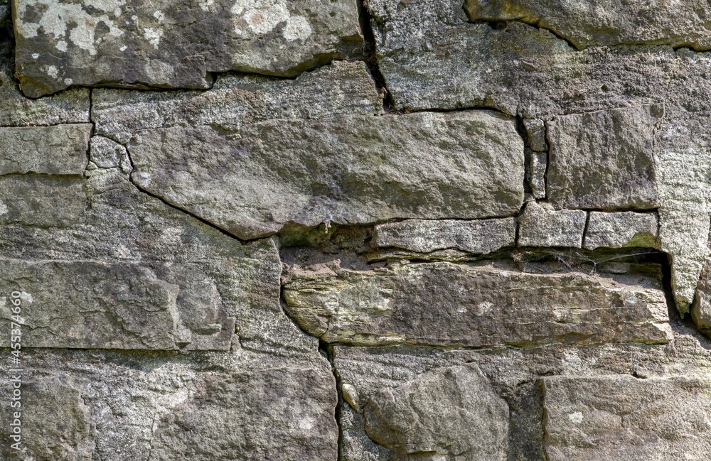 Obraz premium Close up of a weathered outdoor grey stone brick wall
