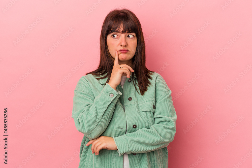 Young curvy caucasian woman isolated on pink background contemplating, planning a strategy, thinking about the way of a business. Young curvy caucasian woman isolated on pink background contemplating, planning a strategy, thinking about the way of a business.