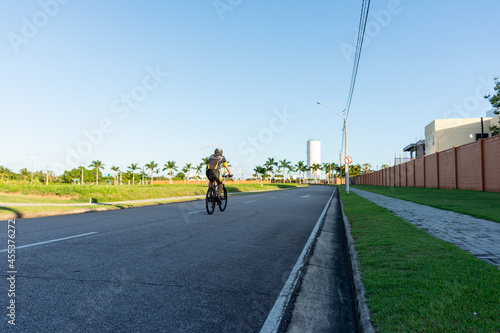 Homem pedala bicicleta ao entardecer 