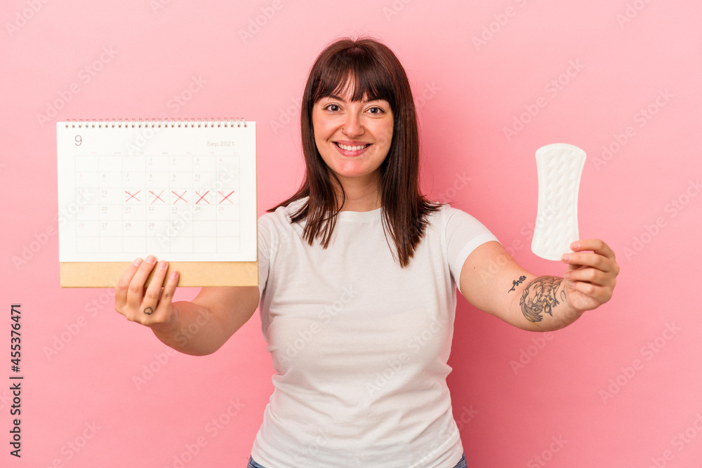 Young curvy caucasian woman holding a calendar compress isolated on pink background Young curvy caucasian woman holding a calendar compress isolated on pink background
