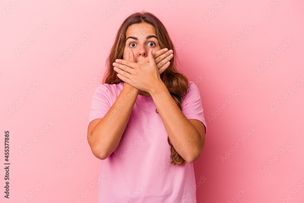 Young caucasian woman isolated on pink background shocked covering mouth with hands. Young caucasian woman isolated on pink background shocked covering mouth with hands.