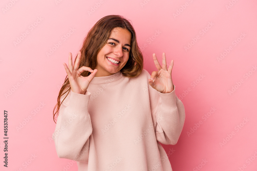 Young caucasian woman isolated on pink background cheerful and confident showing ok gesture. Young caucasian woman isolated on pink background cheerful and confident showing ok gesture.
