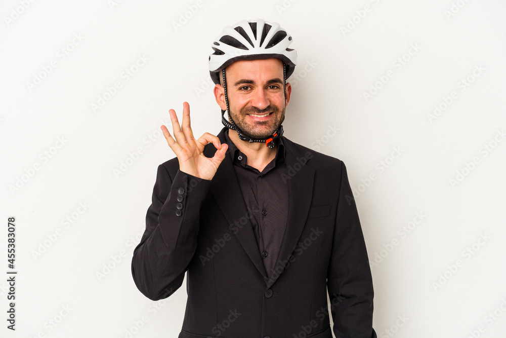 Young business bald man wearing a bike helmet isolated on white background cheerful and confident showing ok gesture. Young business bald man wearing a bike helmet isolated on white background cheerful and confident showing ok gesture.