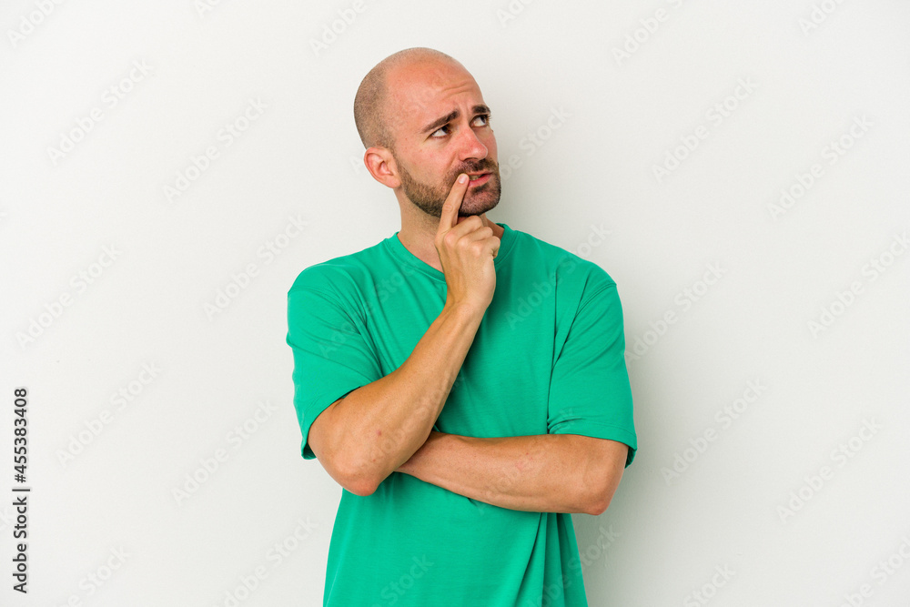 Young bald man isolated on white background looking sideways with doubtful and skeptical expression. Young bald man isolated on white background looking sideways with doubtful and skeptical expression.