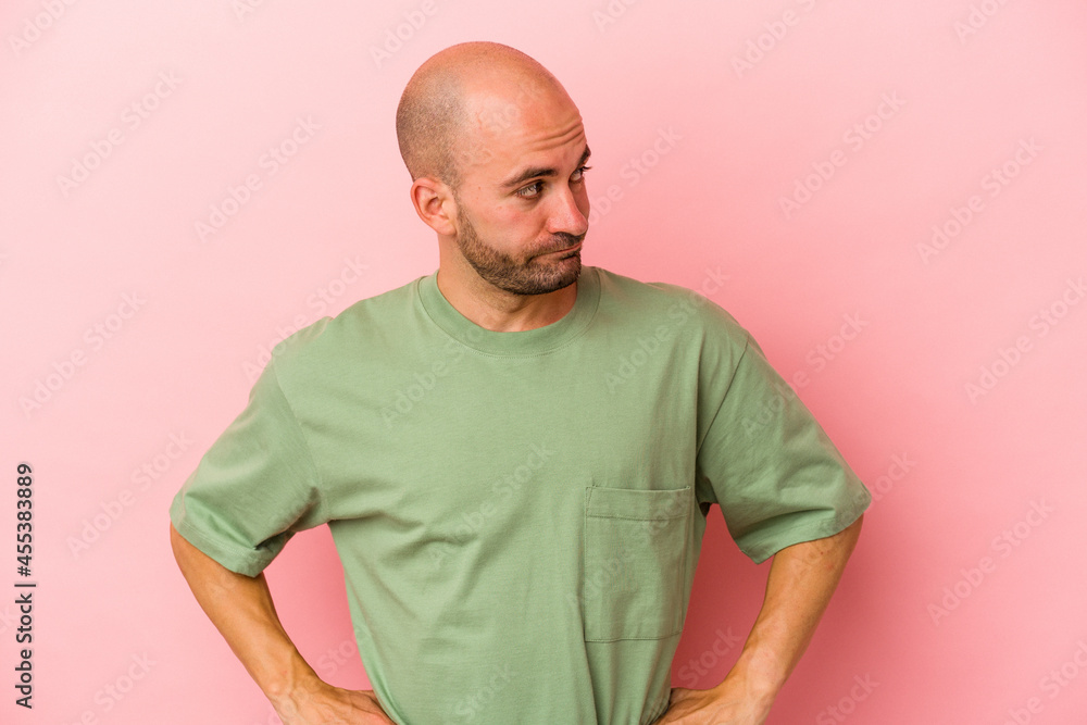 Young caucasian bald man isolated on pink background confused, feels doubtful and unsure. Young caucasian bald man isolated on pink background confused, feels doubtful and unsure.