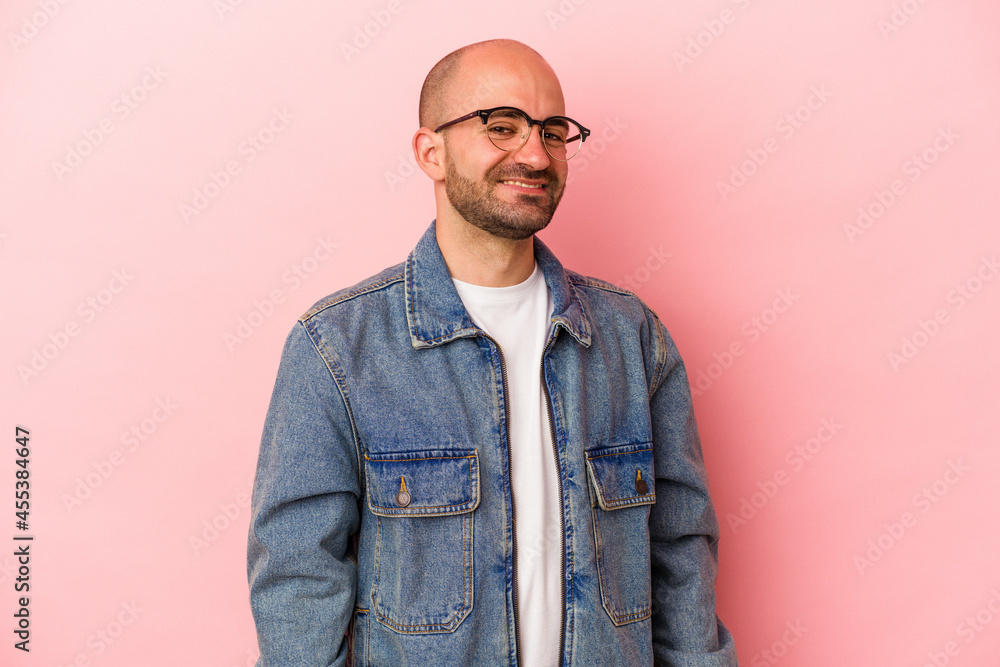Fototapeta premium Young caucasian bald man isolated on pink background confident keeping hands on hips.