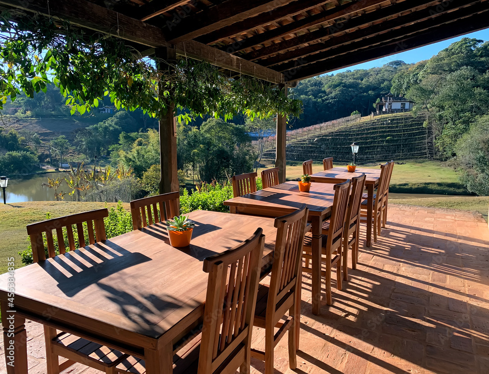 Fototapeta premium Terrace with wooden tables and chairs in a pleasant place in the open sky.