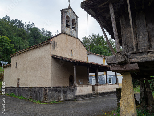 Vistas de la Iglesia de San Julián y su campanario desde el hórreo de enfrente, en Viñon, pueblo de Cantabria, España, verano de 2020 photo