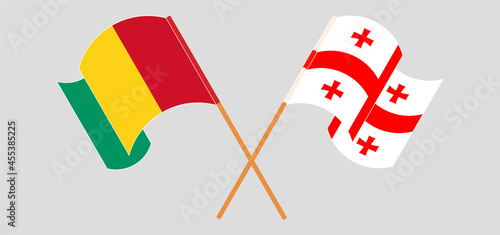 Crossed and waving flags of Guinea and Georgia