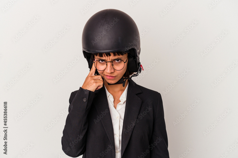 Young mixed race business woman wearing a motorbike helmet isolated pointing temple with finger, thinking, focused on a task. Young mixed race business woman wearing a motorbike helmet isolated pointing temple with finger, thinking, focused on a task.