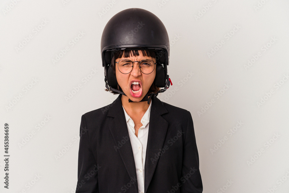 Young mixed race business woman wearing a motorbike helmet isolated screaming very angry and aggressive. Young mixed race business woman wearing a motorbike helmet isolated screaming very angry and aggressive.