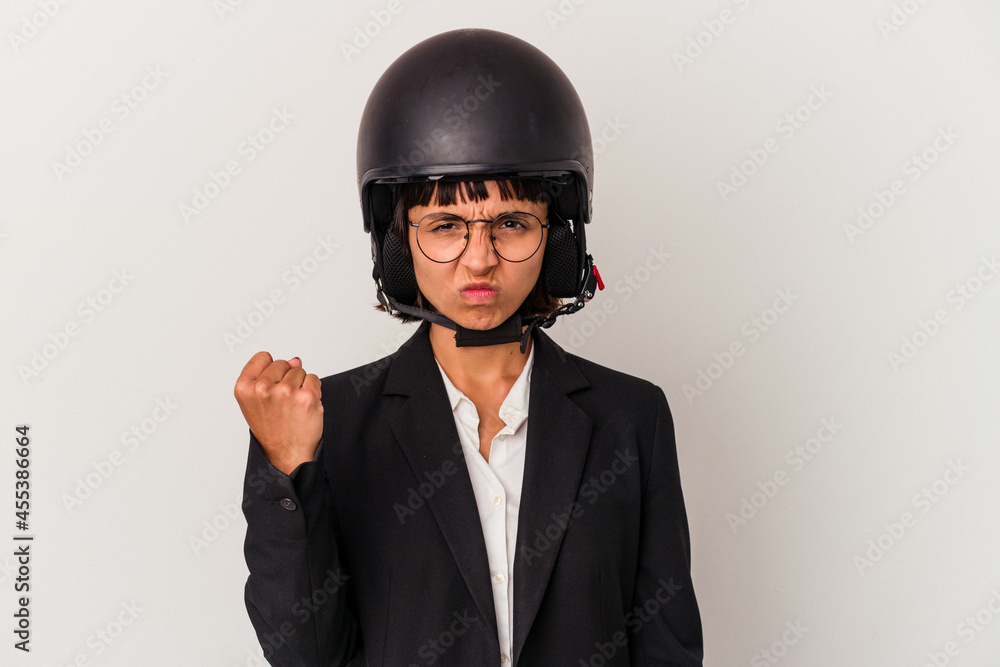 Young mixed race business woman wearing a motorbike helmet isolated showing fist to camera, aggressive facial expression. Young mixed race business woman wearing a motorbike helmet isolated showing fist to camera, aggressive facial expression.
