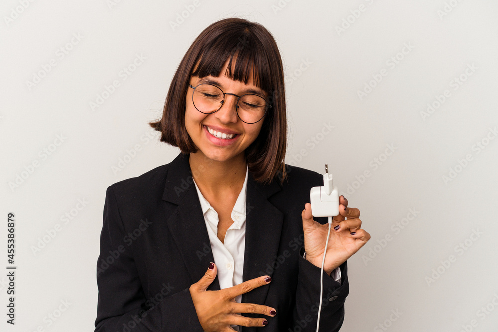 Young mixed race business woman holding a phone charger isolated on white background keeping a secret or asking for silence. Young mixed race business woman holding a phone charger isolated on white background keeping a secret or asking for silence.