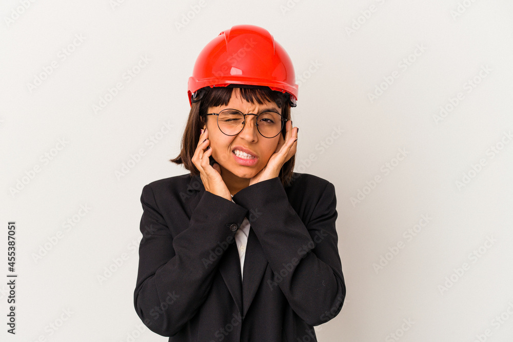 Young architect woman with red helmet isolated on white background covering ears with hands. Young architect woman with red helmet isolated on white background covering ears with hands.