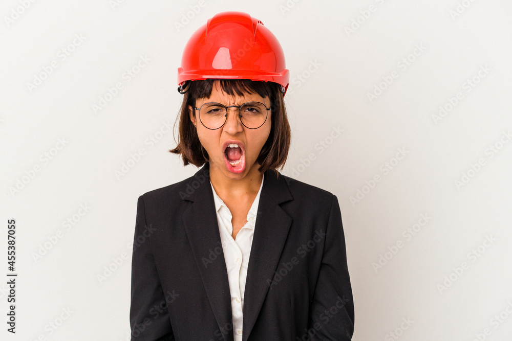 Young architect woman with red helmet isolated on white background screaming very angry and aggressive. Young architect woman with red helmet isolated on white background screaming very angry and aggressive.