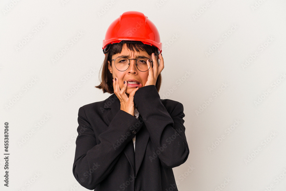 Young architect woman with red helmet isolated on white background whining and crying disconsolately.
