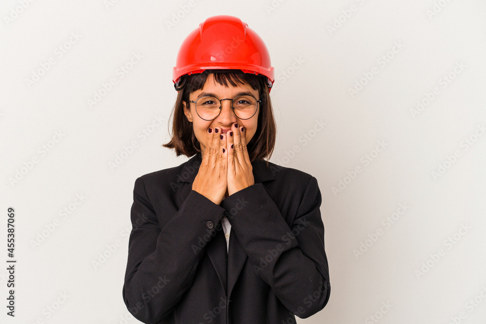 Young architect woman with red helmet isolated on white background laughing about something, covering mouth with hands. Young architect woman with red helmet isolated on white background laughing about something, covering mouth with hands.