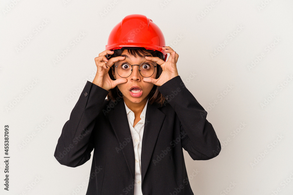 Young architect woman with red helmet isolated on white background keeping eyes opened to find a success opportunity. Young architect woman with red helmet isolated on white background keeping eyes opened to find a success opportunity.