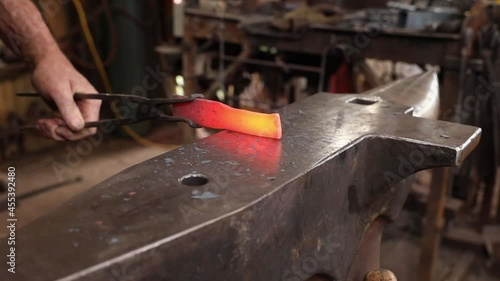 Blacksmith forging iron hammer and anvil