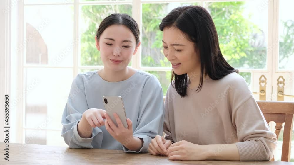 スマートフォンを一緒に使う母と娘 スマートフォンを一緒に使う母と娘