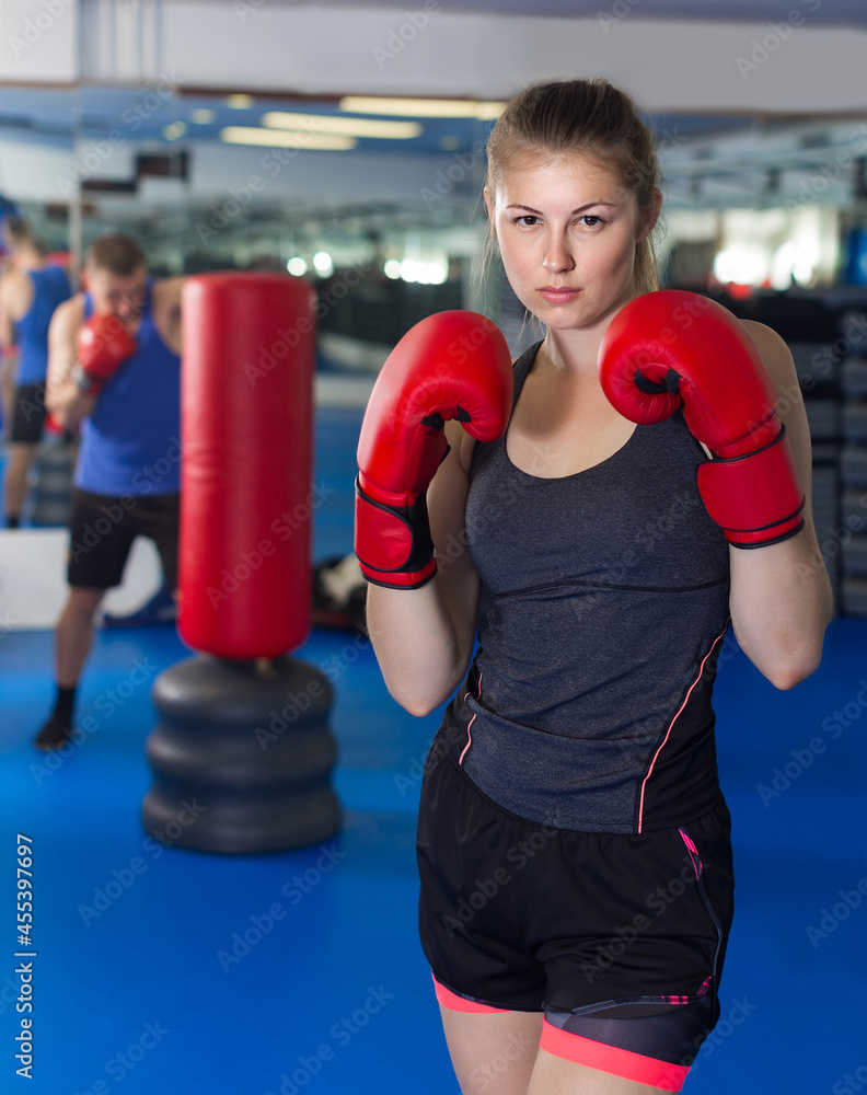 Portrait of positive woman who is training in box gym.