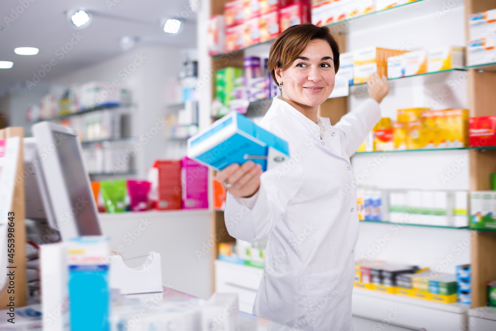 Young female pharmacist suggesting useful drug in pharmacy