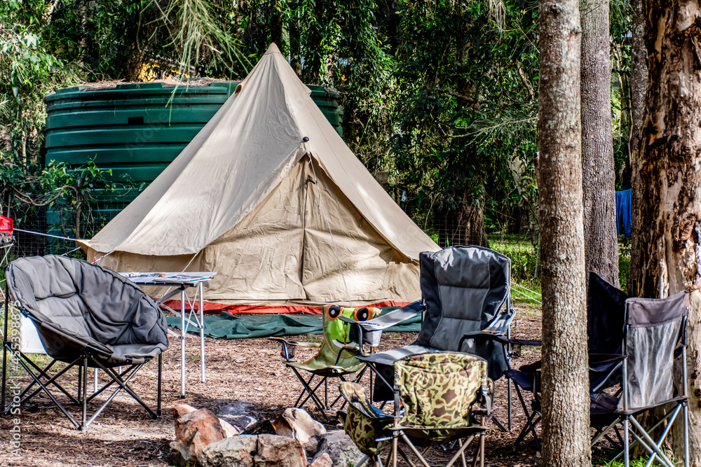Family tent setup at the campsite surrounding by nature in holiday park - obrazy, fototapety, plakaty 