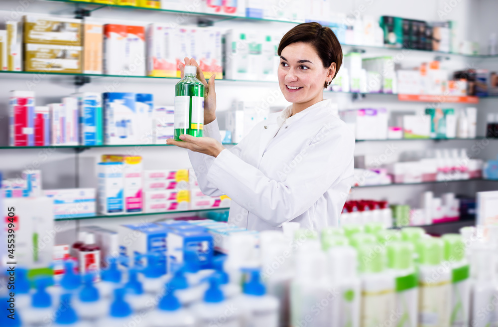 Happy female pharmacist offering products of body care in pharmacy